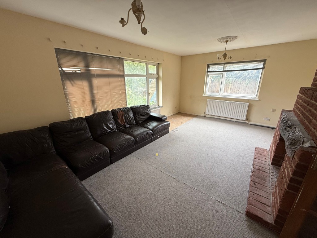 Lot: 136 - FOUR-BEDROOM DETACHED HOUSE FOR REPAIR AND MODERNISATION - Living room showing windows on two walls
